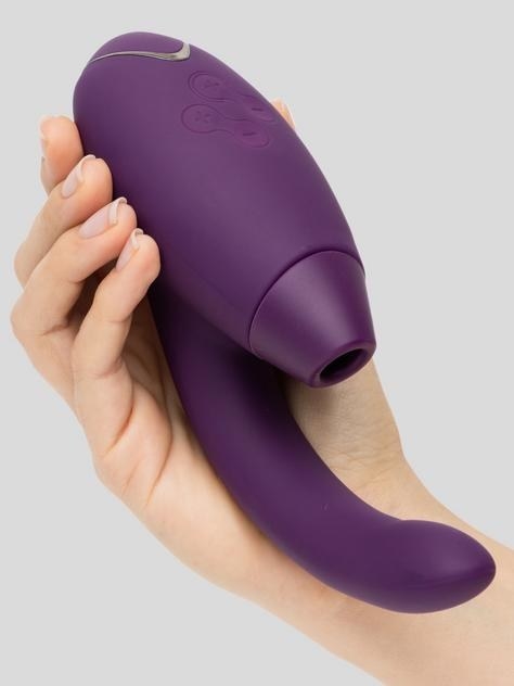 A hand holding the stimulator in purple