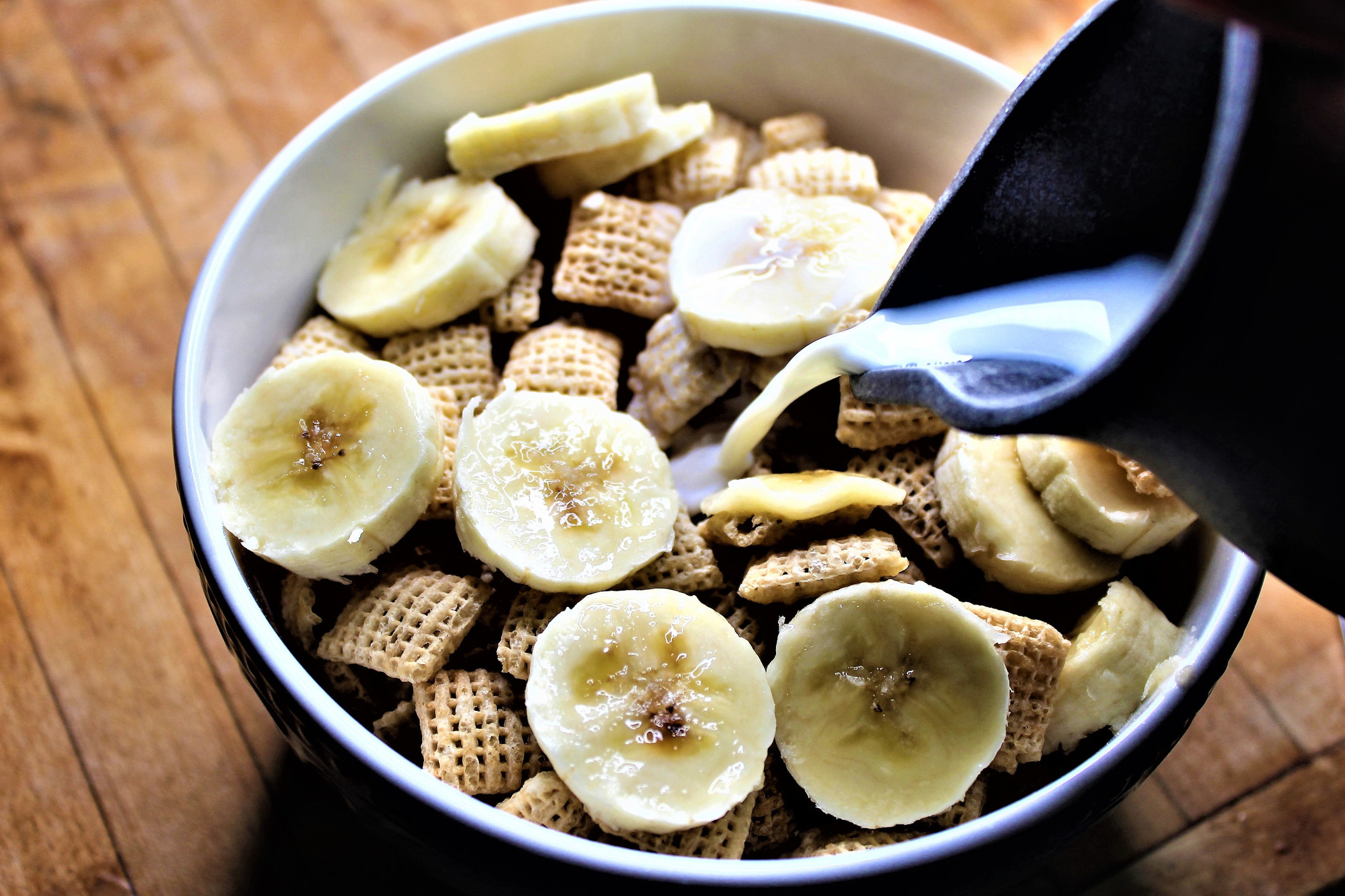 Bananas and Chex cereal in a bowl.