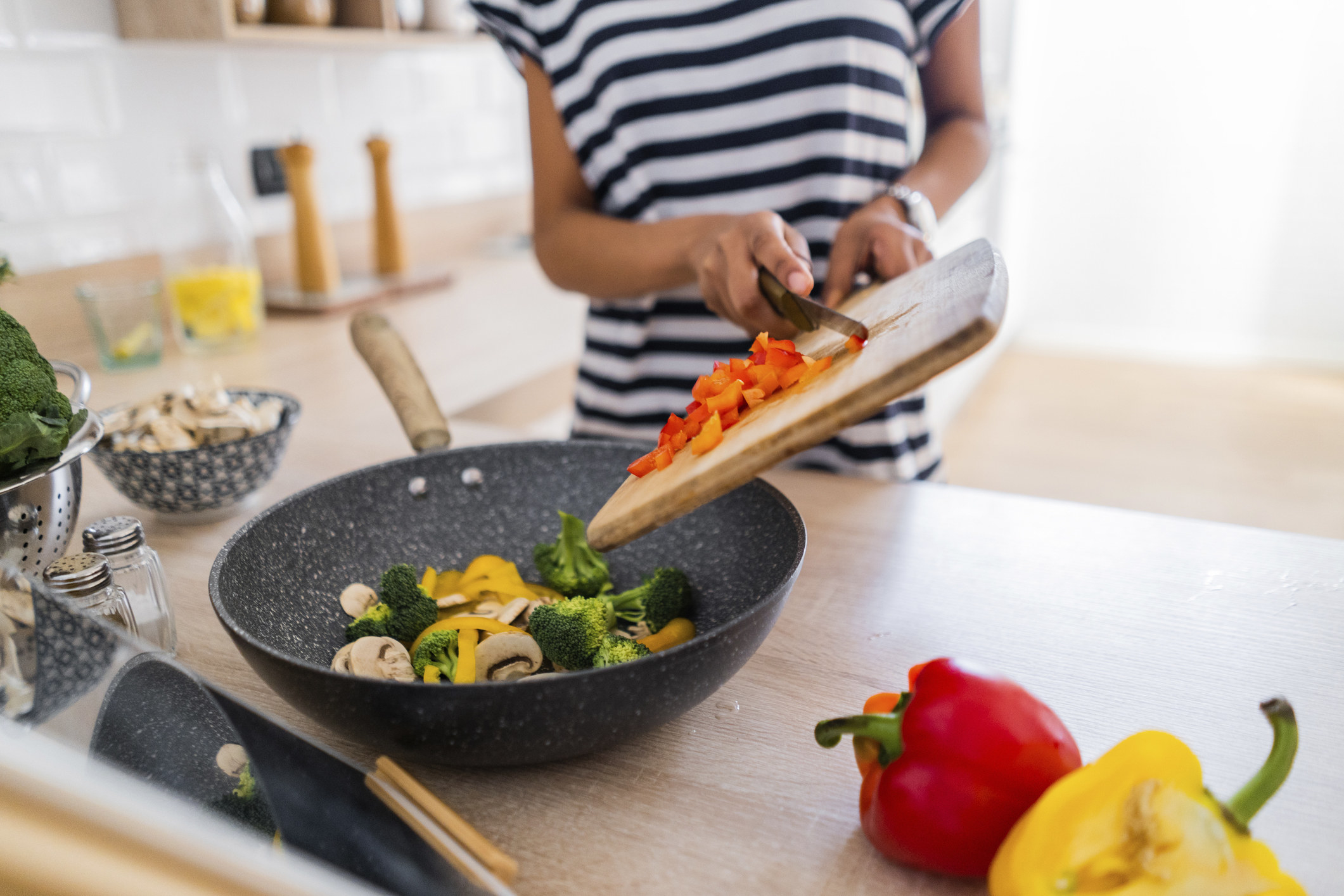 Close-up of young woman with tablet cooking in kitchen at home.