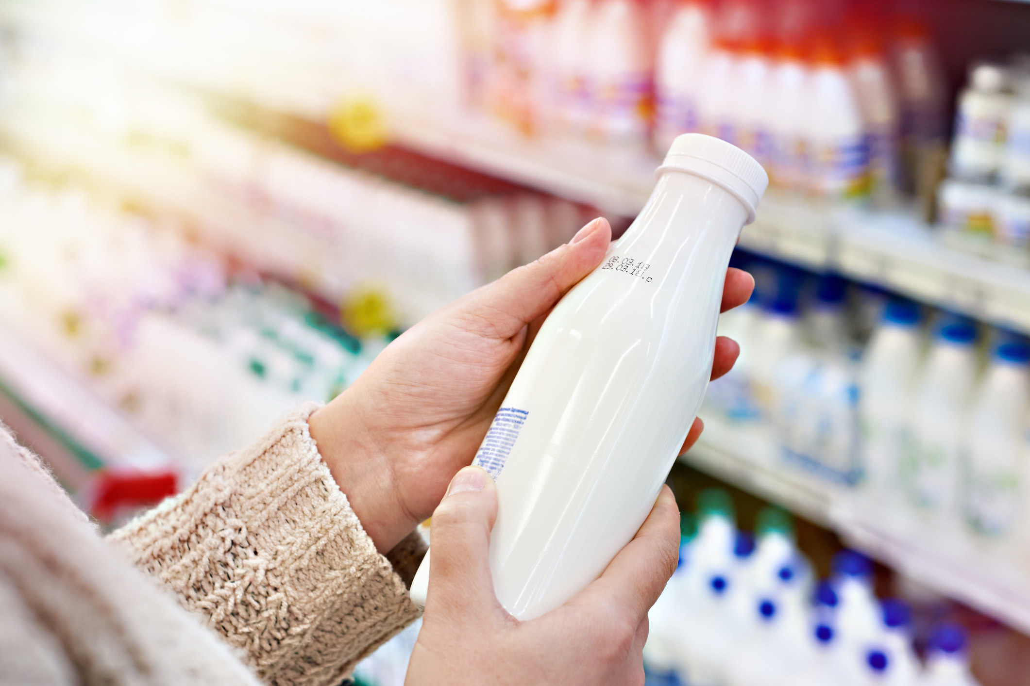 A woman examining a bottle of milk.