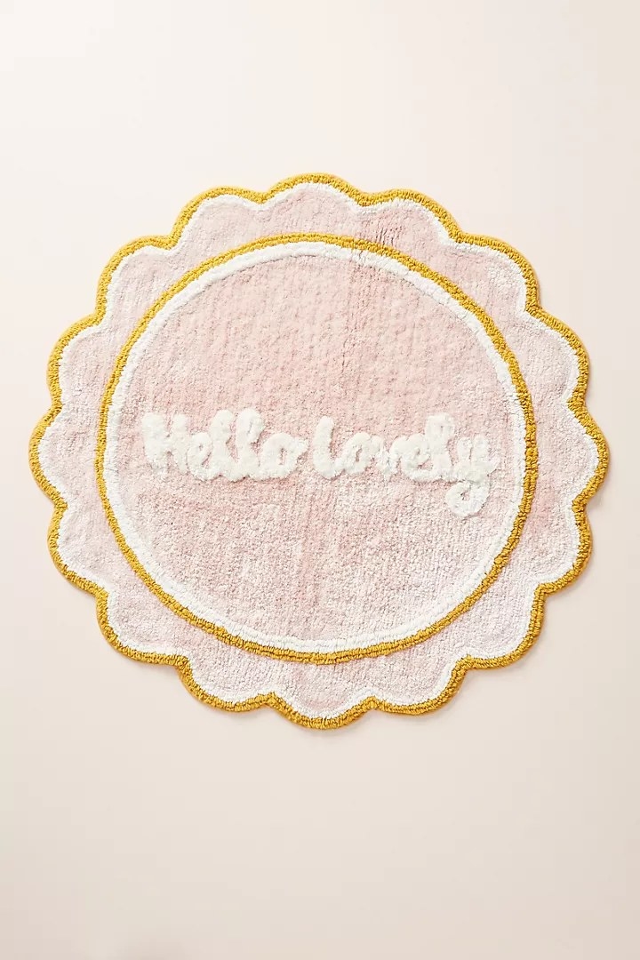 The bath mat, which reads Hello Lovely in curly cursive letters