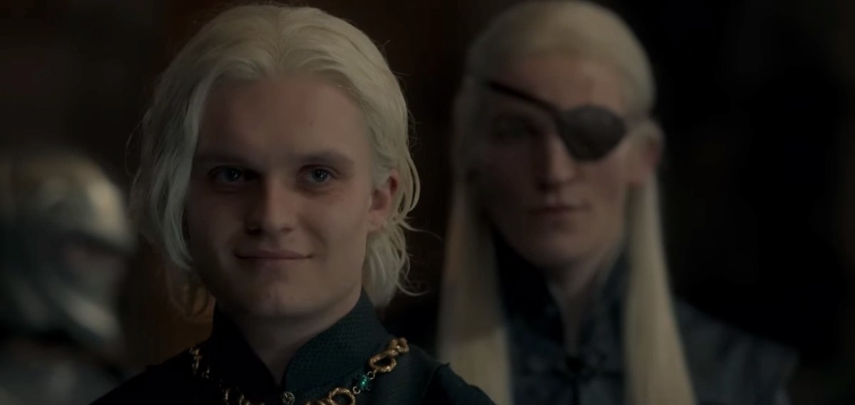 Aegon smiles with Aemond standing behind him