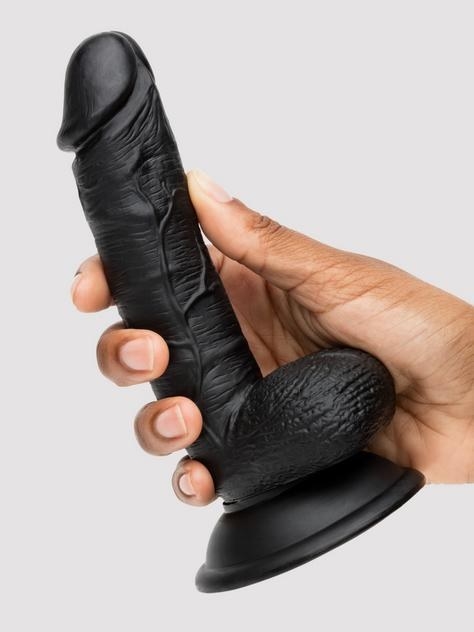 A hand holding the dildo in black