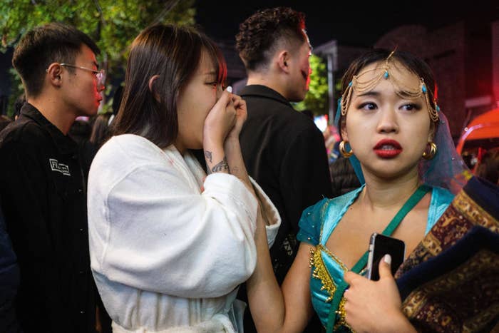 One woman holds her hands to her face as another touches her arm