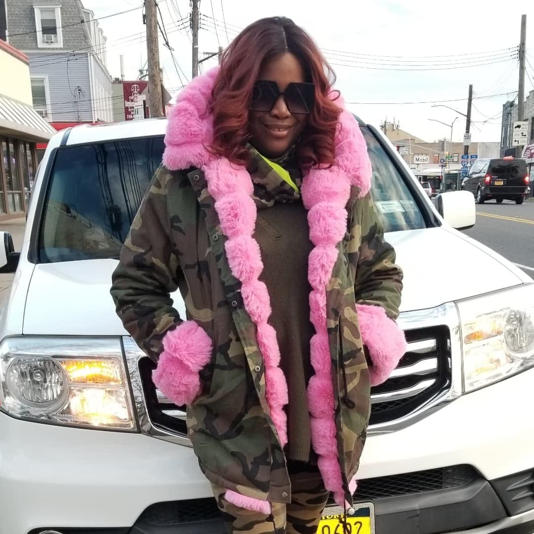 reviewer in camo coat with pink faux fur trim on the inner lining, hood, and cuffs