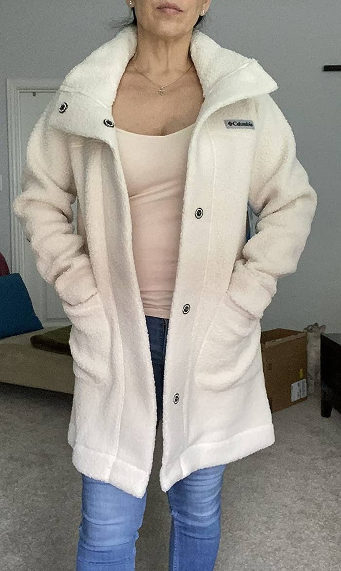 Reviewer wearing the white snap front coat open, with hands in pocket