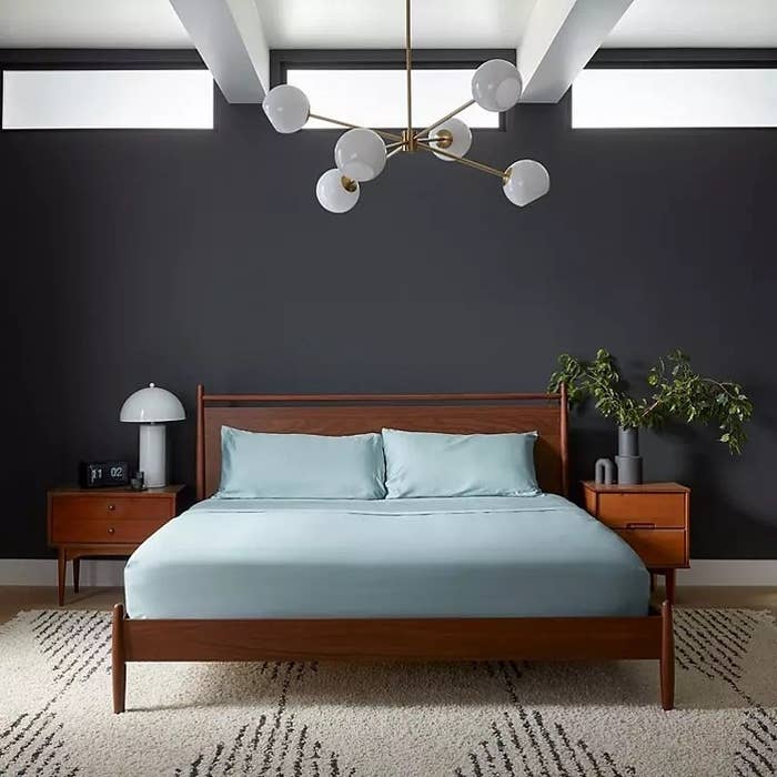A brown bed with blue sheets