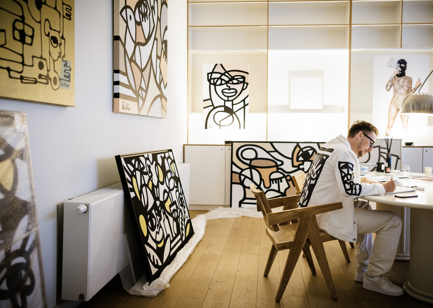 pablo lucker&#x27;s gallery with a number of prints displayed and pablo working at his desk