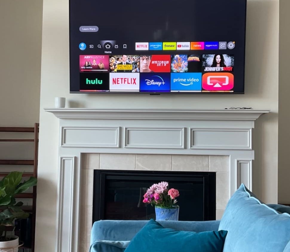 a reviewer photo of the TV mounted above a fireplace