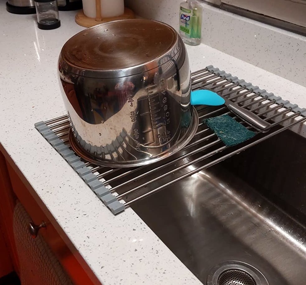 a reviewer photo of a stock pot drying on the rack over a sink