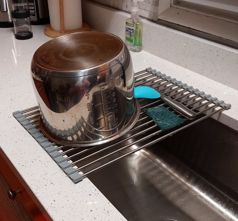 a reviewer photo of a stock pot drying on the rack over a sink