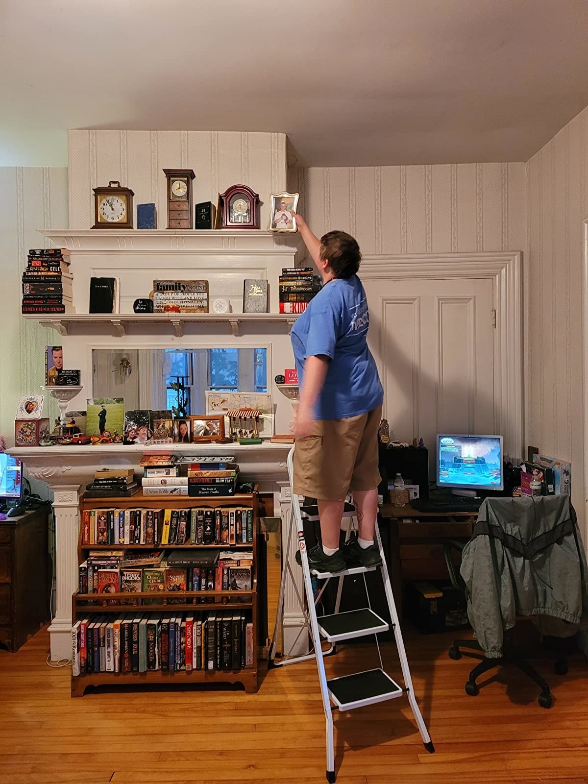 a reviewer stepping on the ladder in white to reach a top shelf