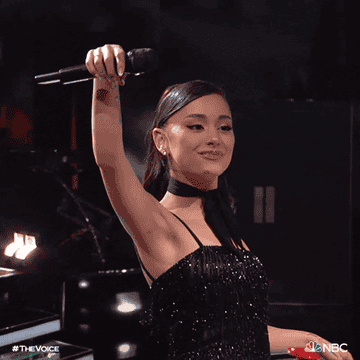 a gif of Ariana Grande dropping a mic