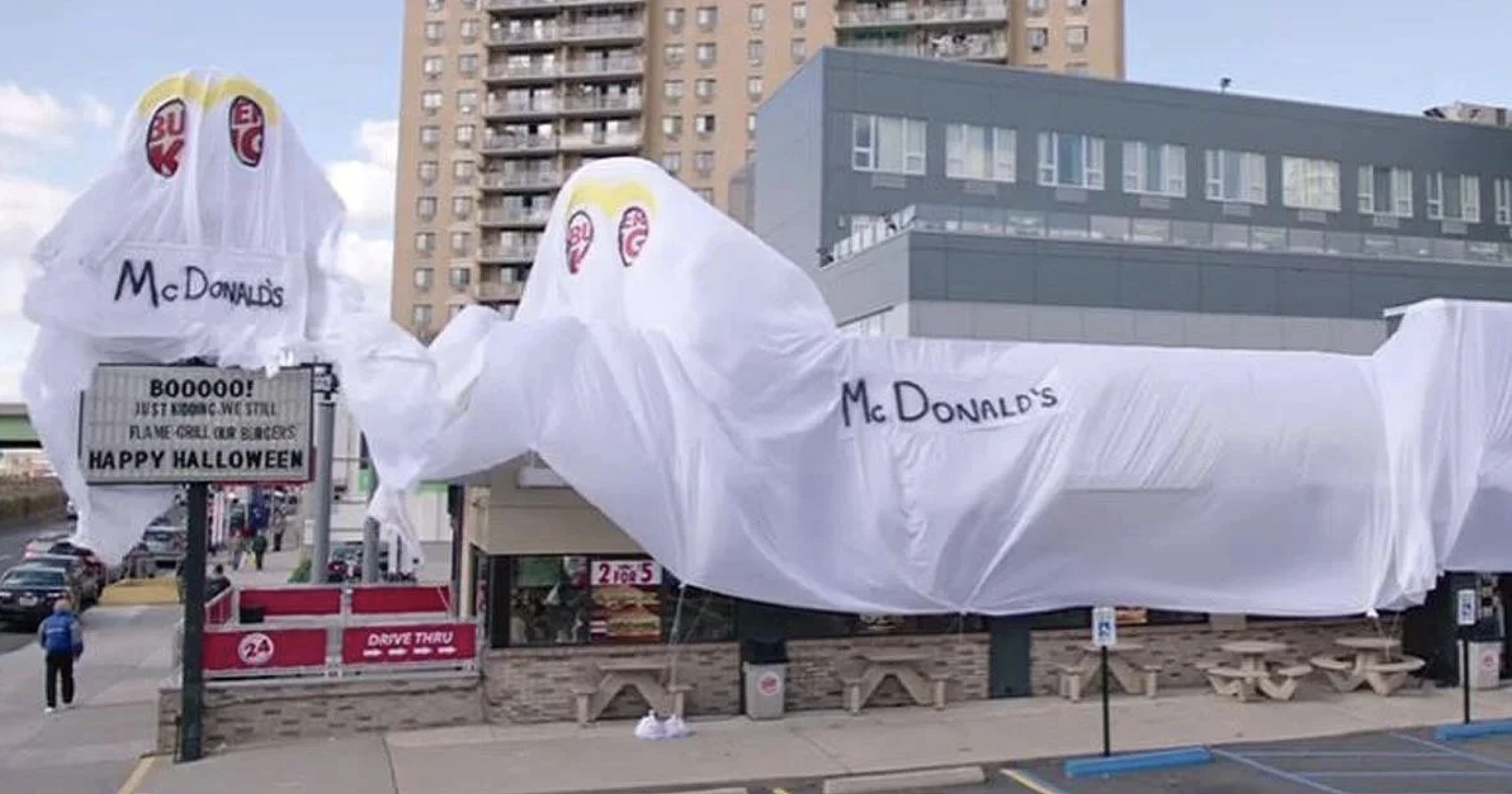 A white plastic cover with &quot;McDonald&#x27;s&quot; written on it covering the Burger King restaurant, with &quot;eyes&quot; showing part of the Burger King logo