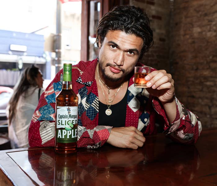 Actor Charles Melton enjoys a Captain Morgan Sliced Apple cocktail during a happy hour at Buck Wild on September 08, 2022 in Austin, Texas