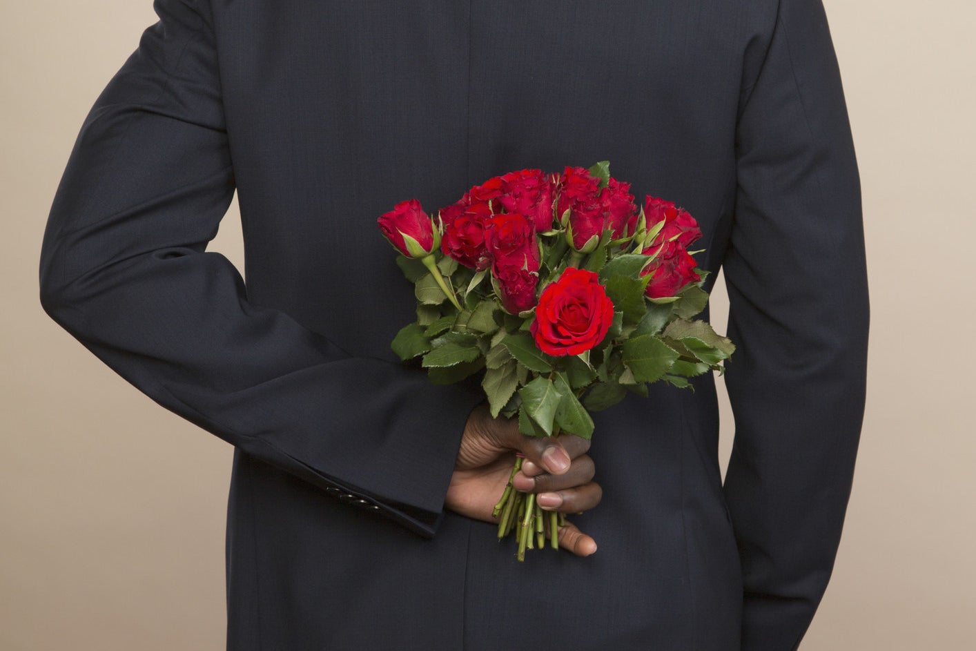 a man holding roses behind his back
