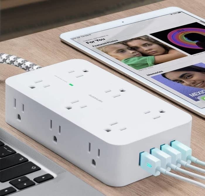 the power bar on a desk with 12 ac outlets and four usb outlets