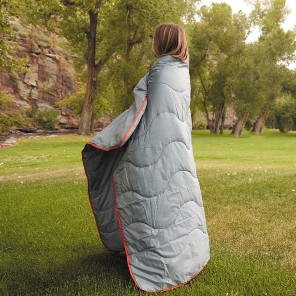 a person wrapped in the packable blanket