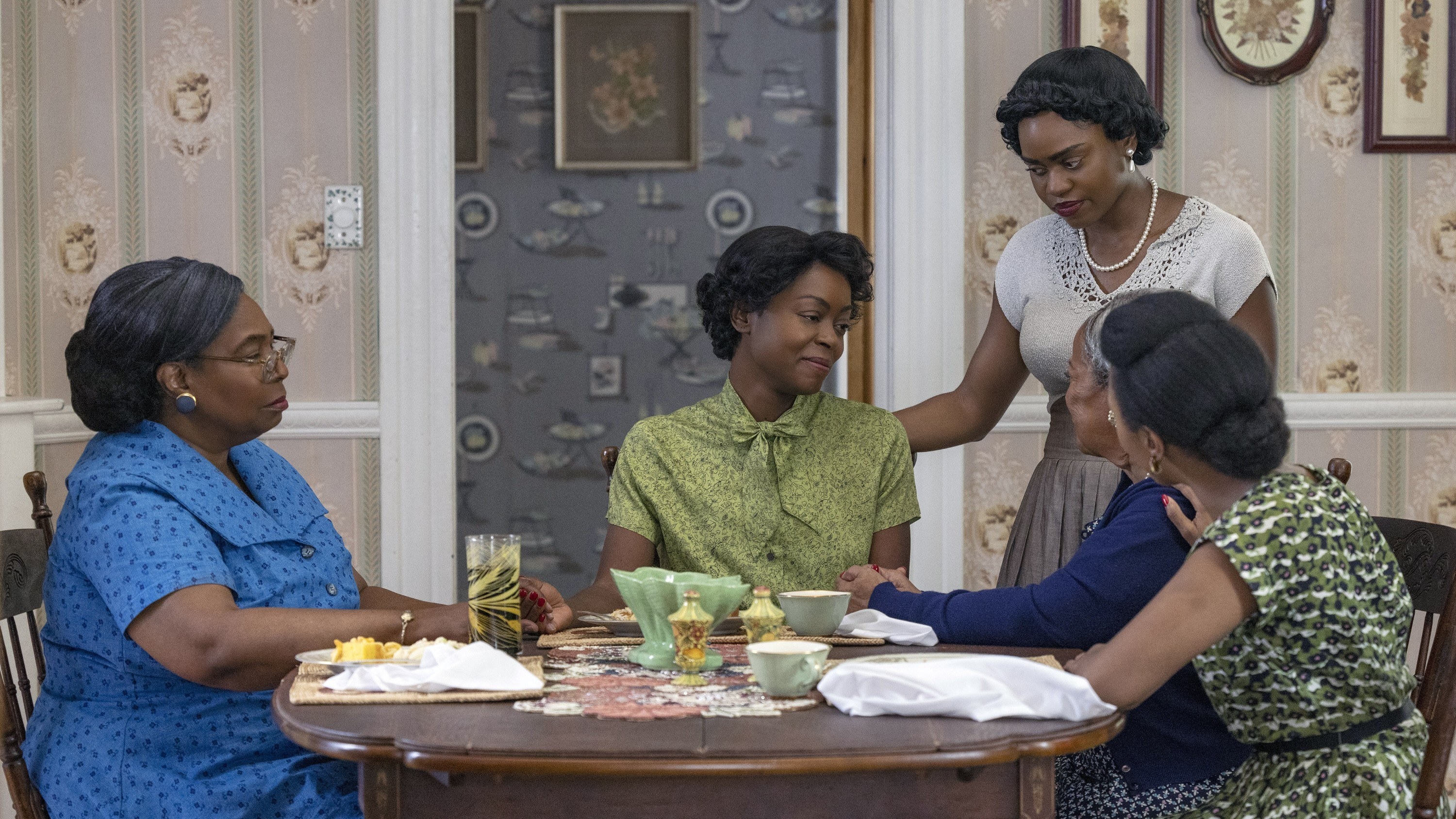 Whoopi sitting at the dinner table with other women in the film