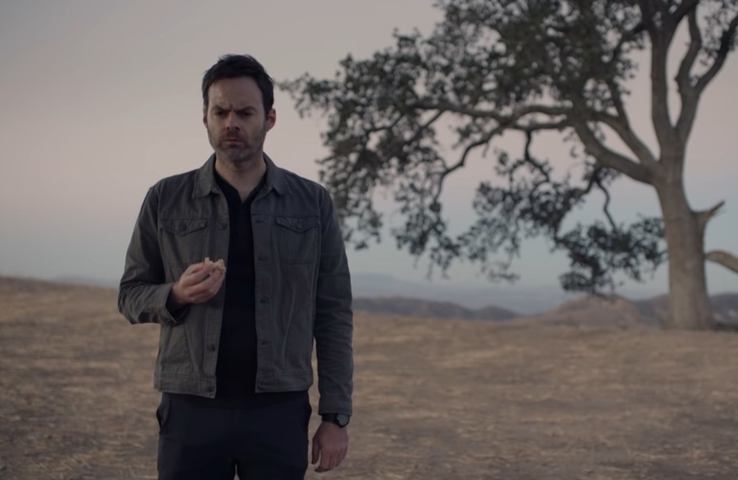 Bill Hader as Barry staring out into the distance while eating something atop a hillside