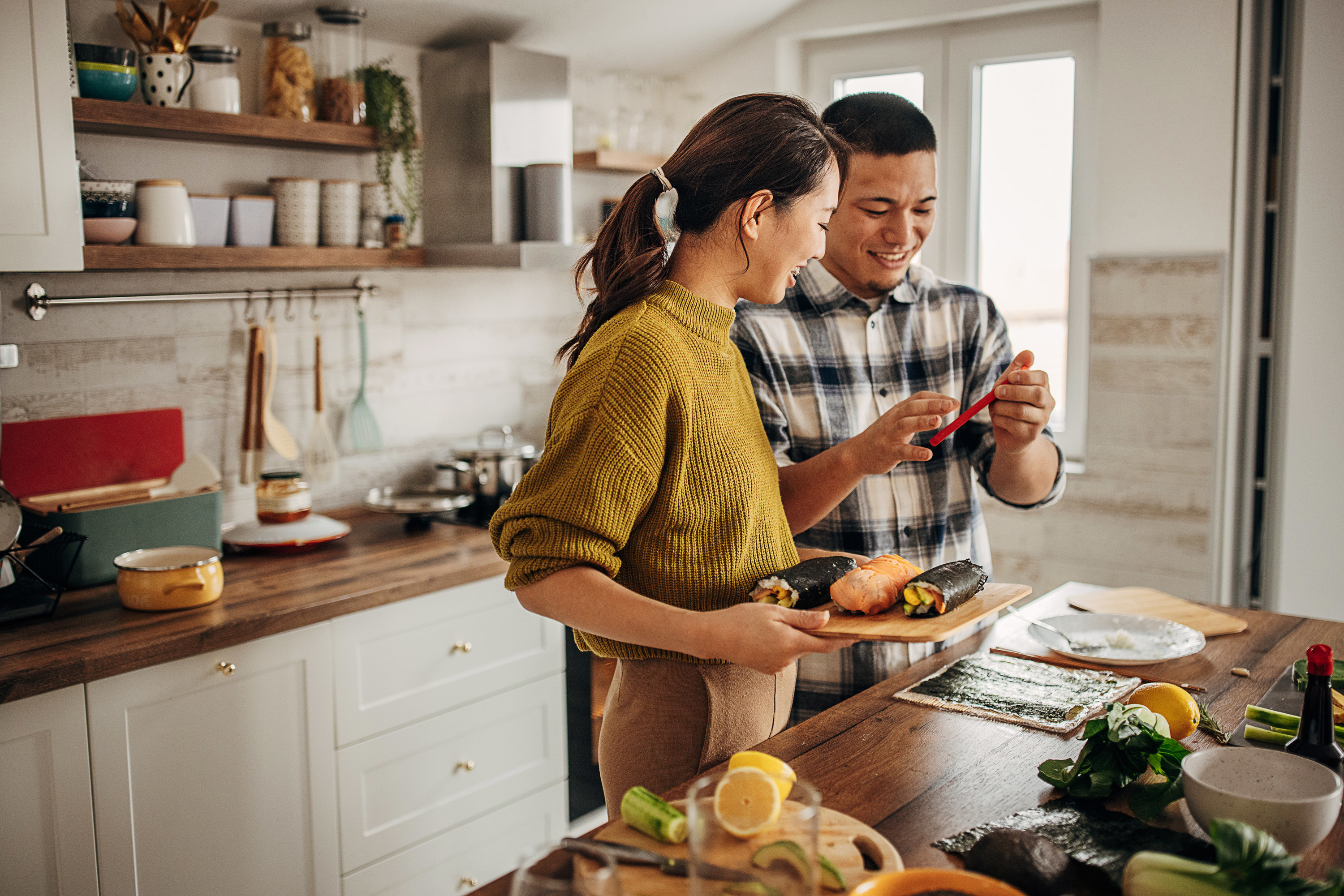 A couple learning to cook together in their home kitchen