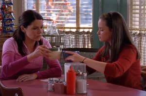 Lorelai and Rory are drinking coffee at a table