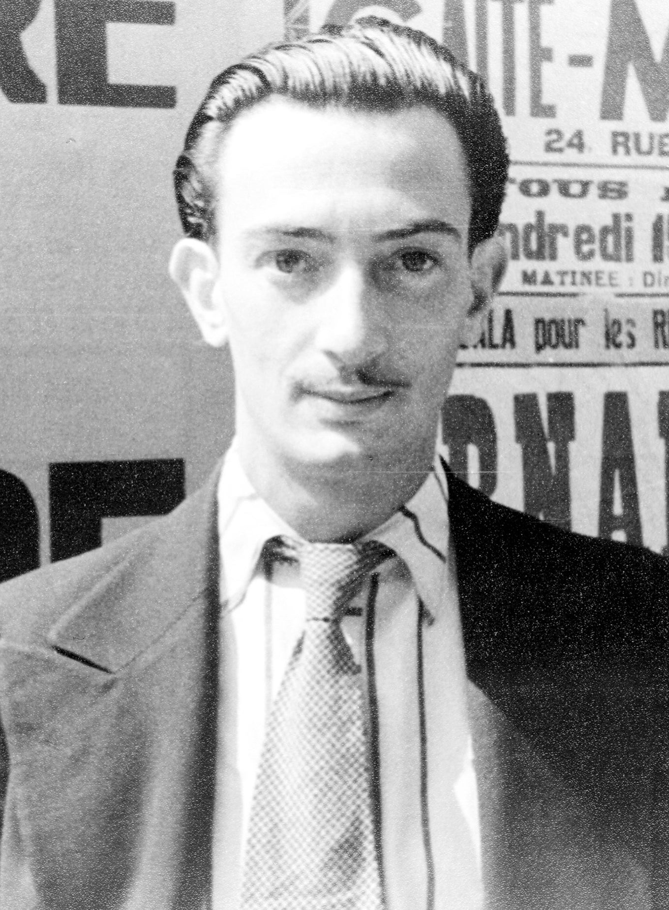 Black-and-white photo of Salvador as a young man in a suit, with a pencil mustache