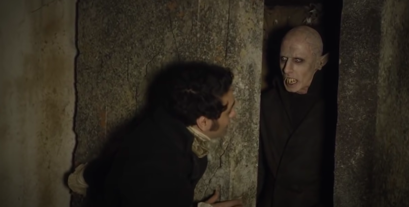 A man opens a tomb with a scary vampire in it