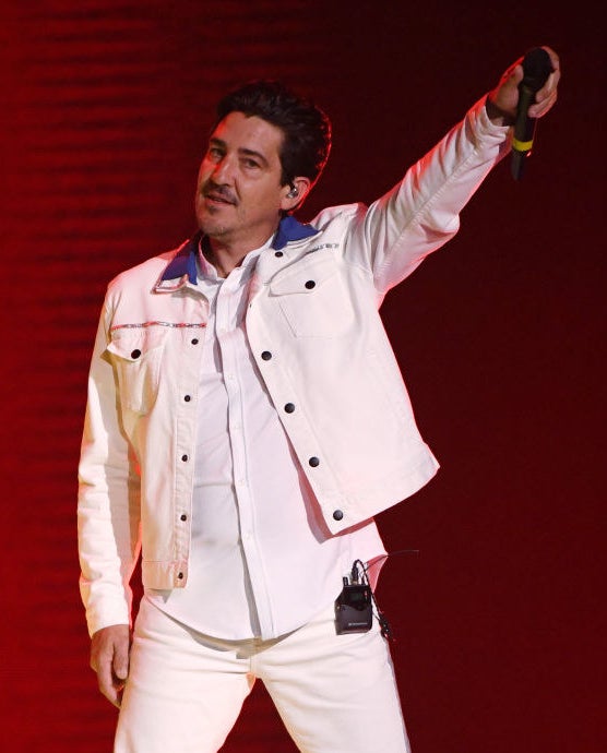 Jonathan Knight holding out a mic