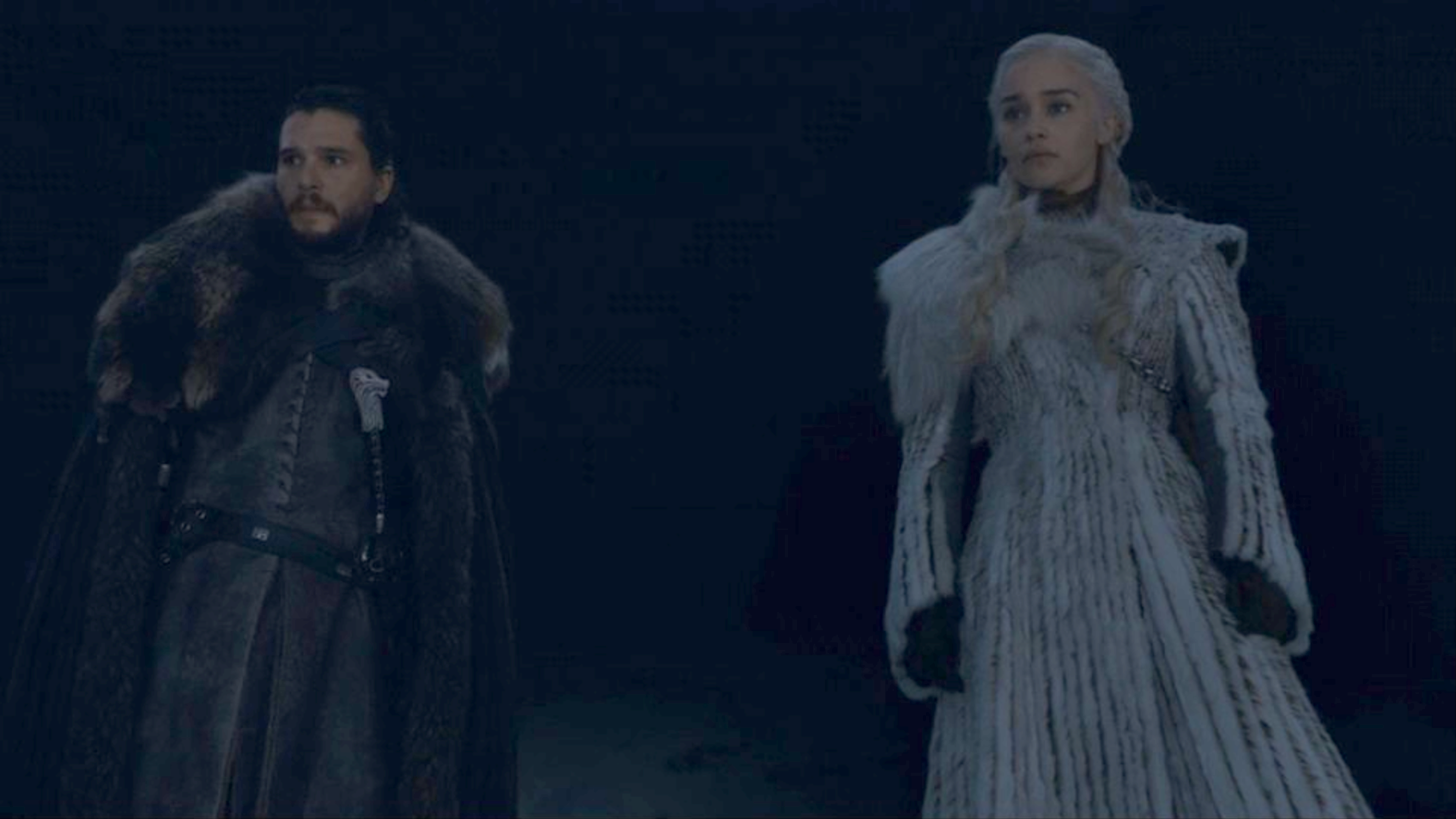 Jon Snow and Daenerys Targaryen standing on a hill at night