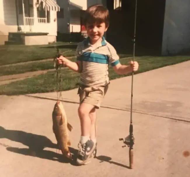 a kid holding a fish he caught