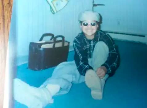 a kid smiling and tying their shoe