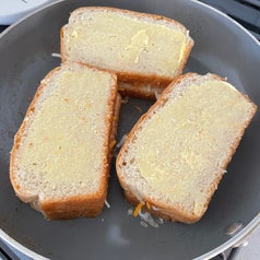 grilled cheese sandwiches cooking in a pan