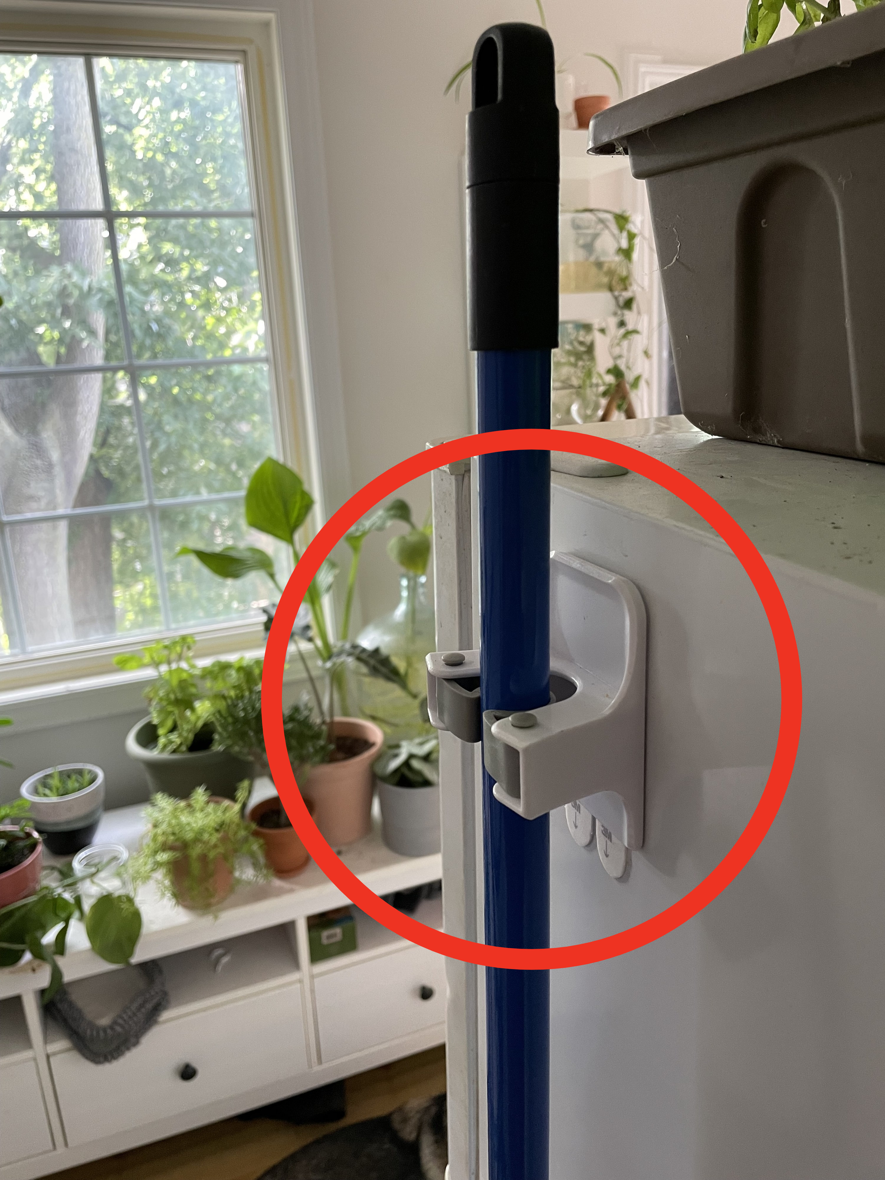 a broom stick hanging from the adhesive holder