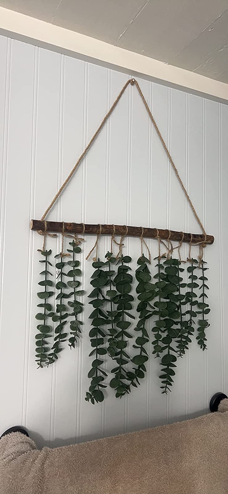 reviewer photo of a wood stick with 12 eucalyptus branches hanging from it
