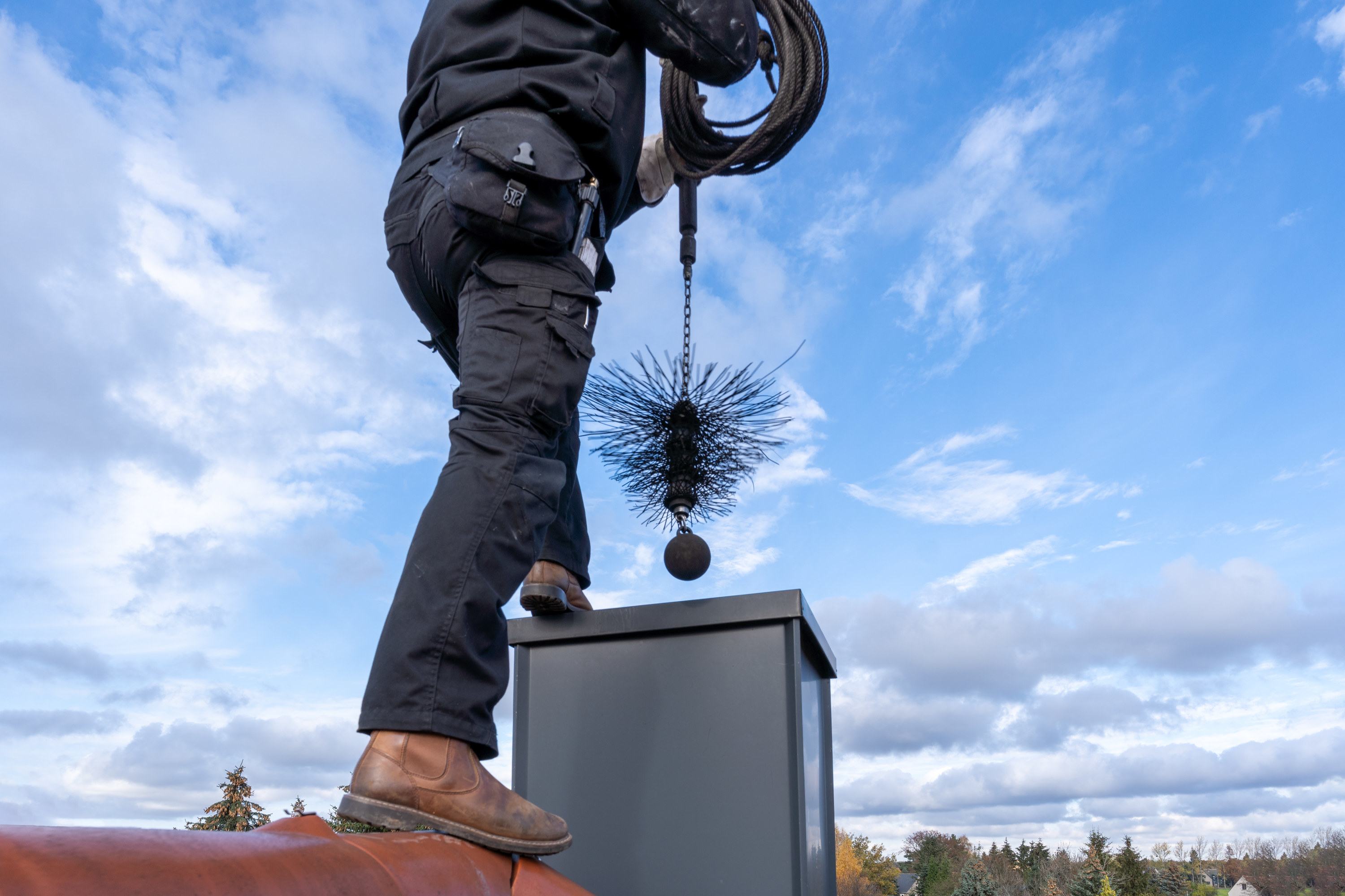 chimney cleaner cleaning chimney from the roof