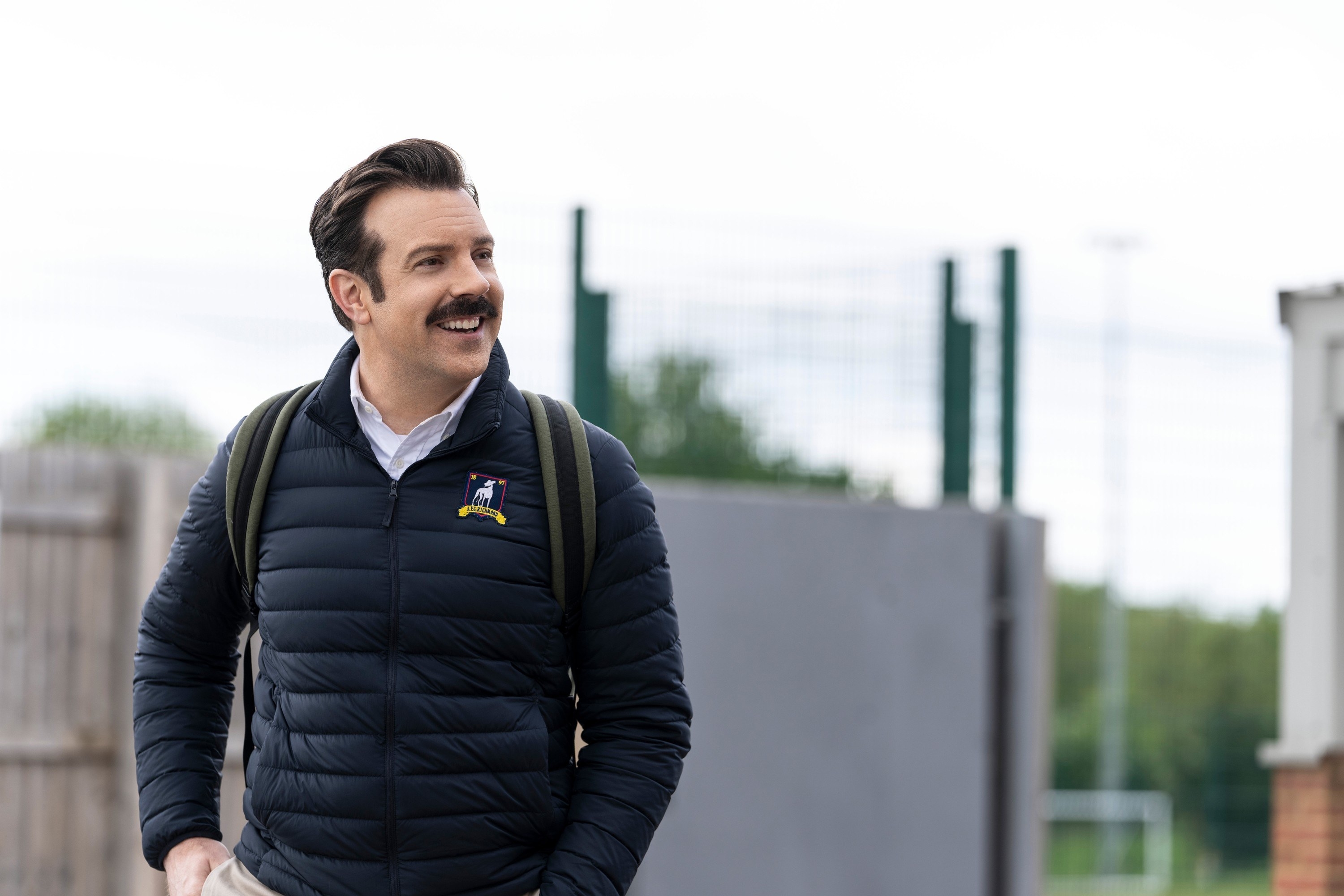 Ted Lasso in a bubble jacket smiling