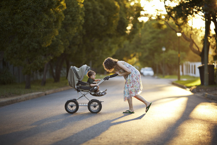 woman pushing a stroller in the street