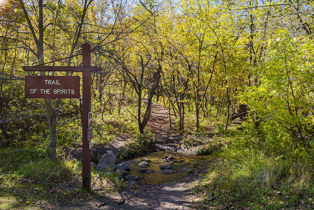 Wooded trail over a red stream