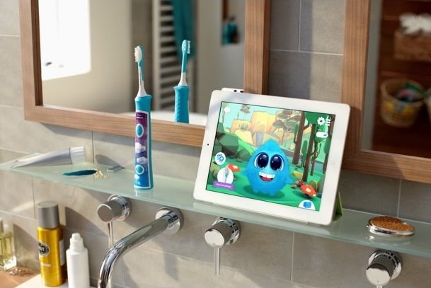 the toothbrush and a tablet showcasing the app