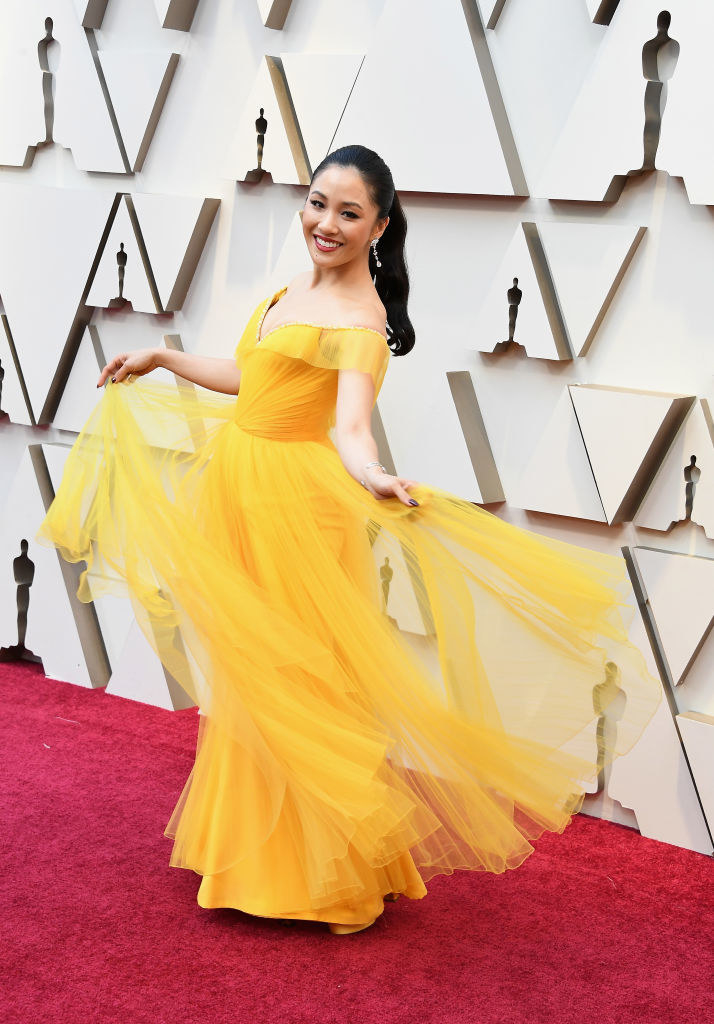 Constance smiling on the Oscars red carpet and twirling her dress