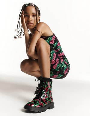 model wearing black combat boots with a rose print and a matching bodysuit