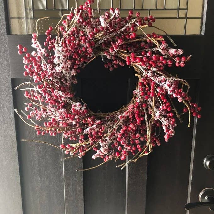 Reviewer&#x27;s photo of the wreath, hung on a black front door