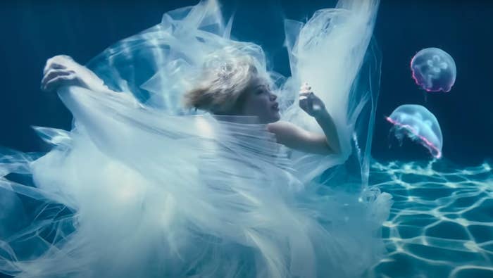A woman apparently underwater and wearing a gauzy gown