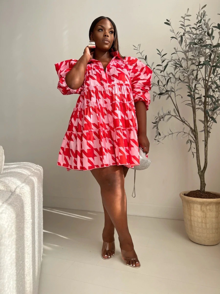 model wearing the puff-sleeve baby doll dress in pink/red checkered pattern