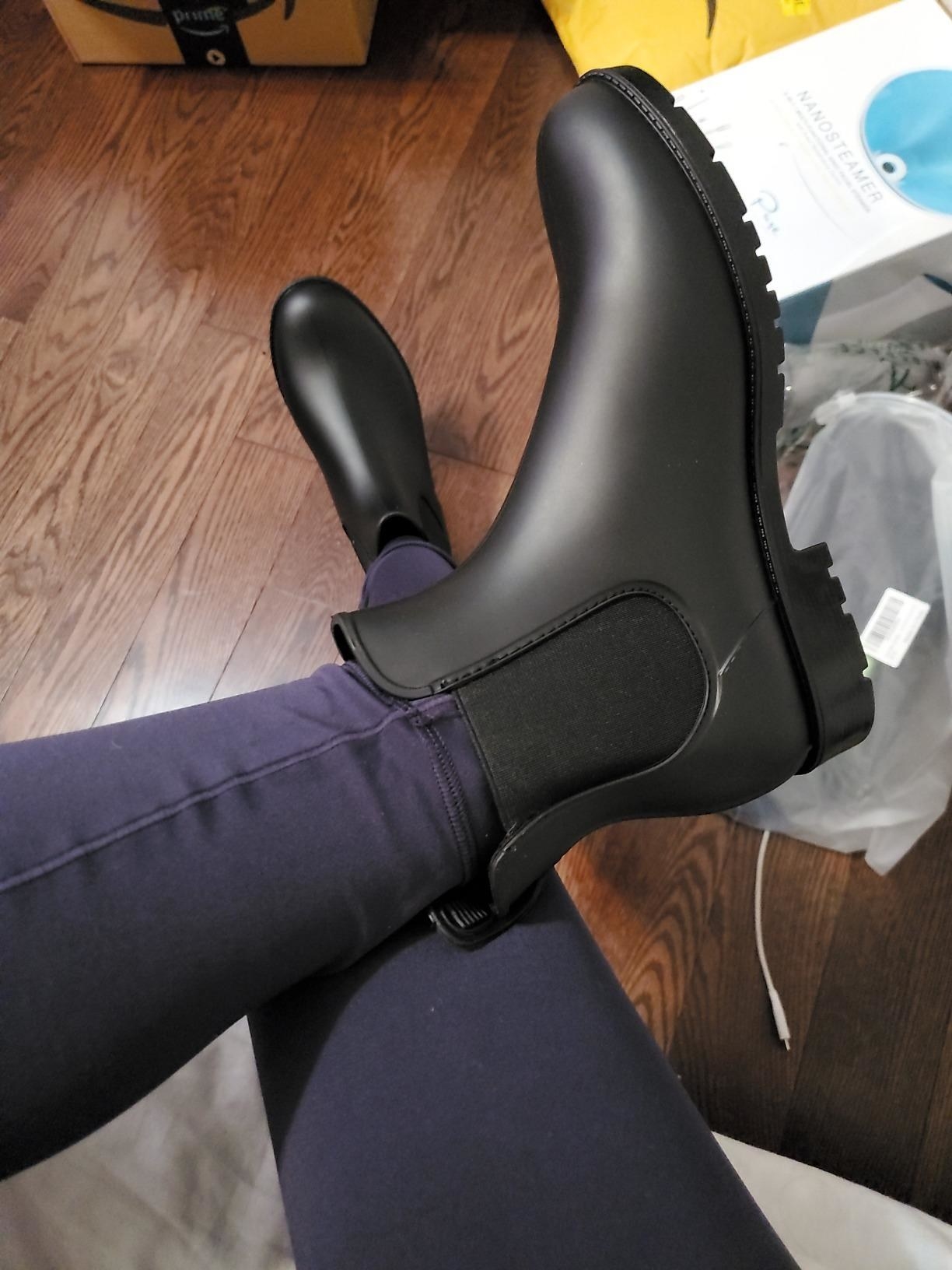 Reviewer wearing black ankle rain boots