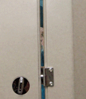 Person looking through the gap of a public bathroom door