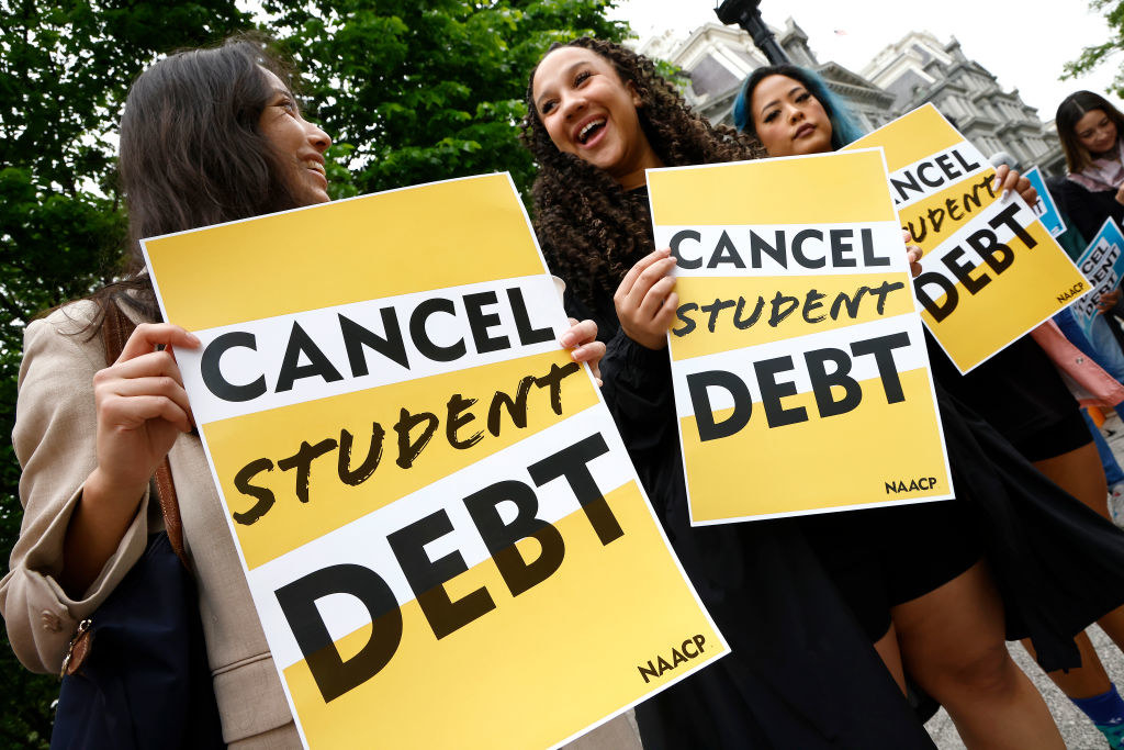 Protesters holding up &quot;Cancel student debt&quot; signs