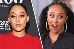 Tia Mowry wears a red dress with a wrap detail and diamond earrings with her hair in a sleek bun. Tamera Mowry wears a denim top with green, marbled hoop earrings.