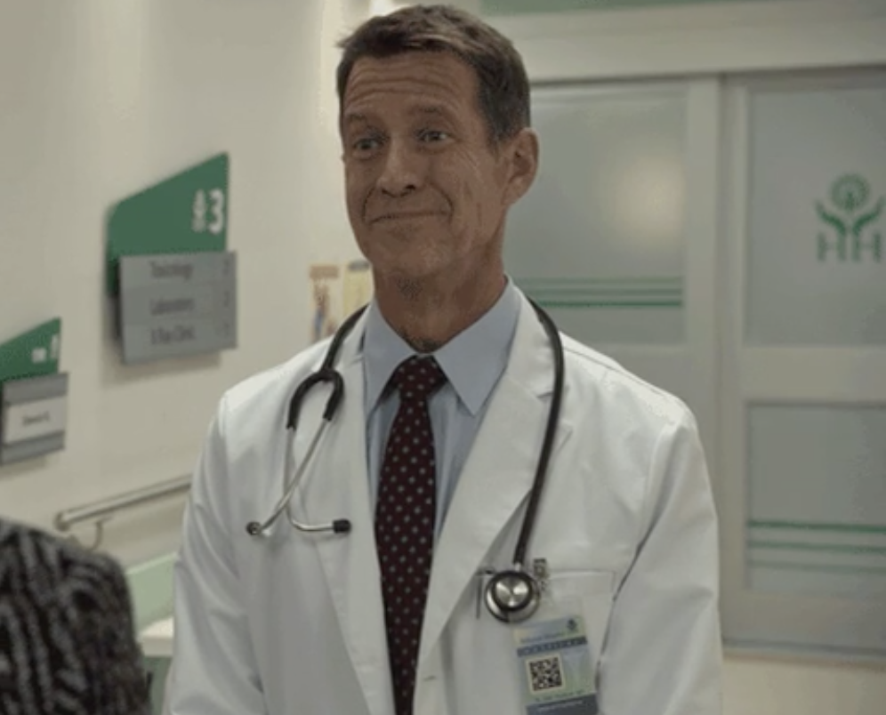 A doctor standing with a smirk on his face